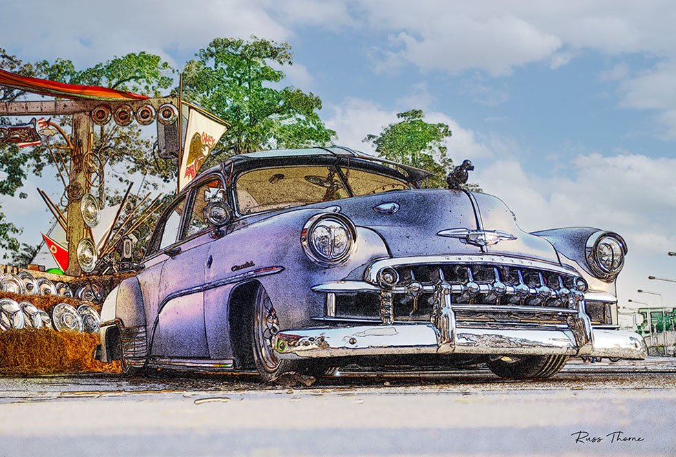 A beautifully fully restored 1940s Chevrolet sedan on display at a car show, reflecting its vintage elegance.