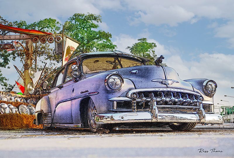 A beautifully fully restored 1940s Chevrolet sedan on display at a car show, reflecting its vintage elegance.