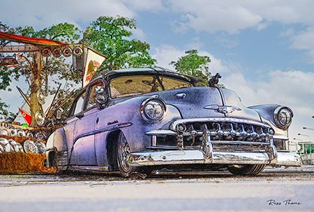 A beautifully fully restored 1940s Chevrolet sedan on display at a car show, reflecting its vintage elegance.