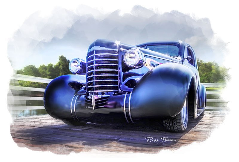 An early 1940s beautifully restored coupe parked on a pier by a tranquil lake, surrounded by lush, vibrant trees.