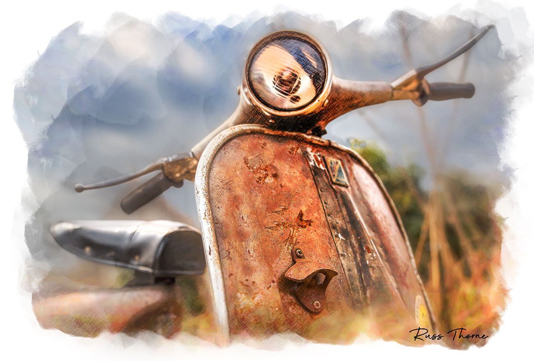 A rusting vintage Vespa scooter, partially hidden in tall weeds, reflecting years of beautiful patina.