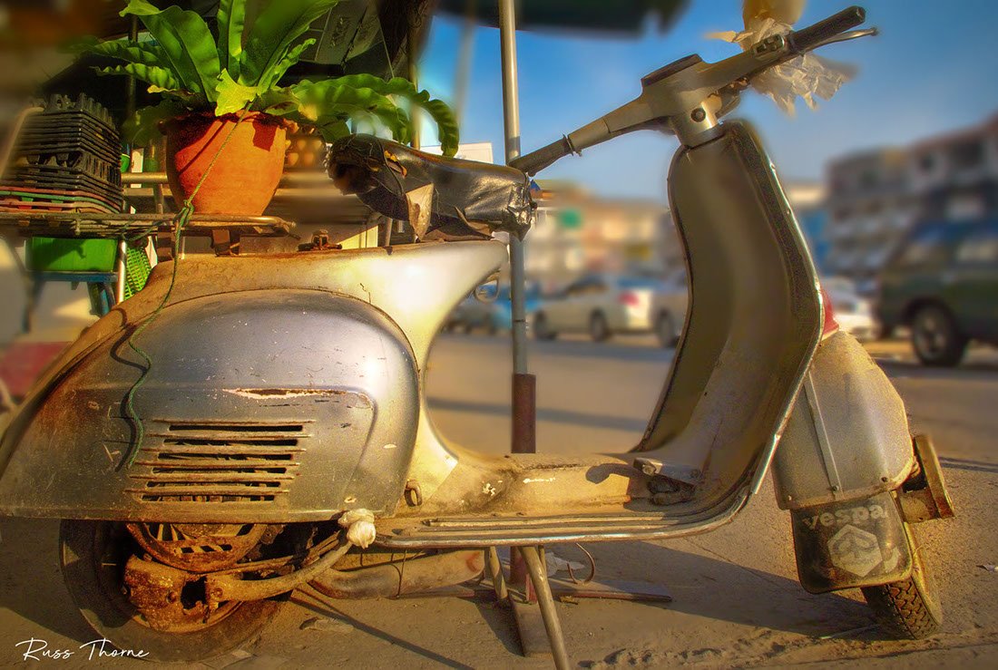 A rustic Vespa scooter, delivering eggs in Bangkok since the 1960s, exuding vintage charm and character.